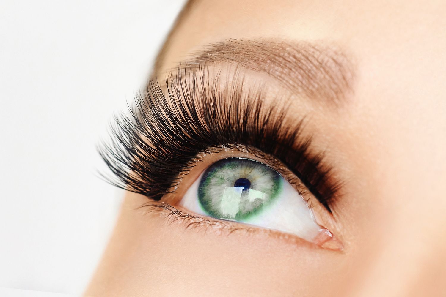 Auge einer Frau mit grünen Augen und langen Wimpern